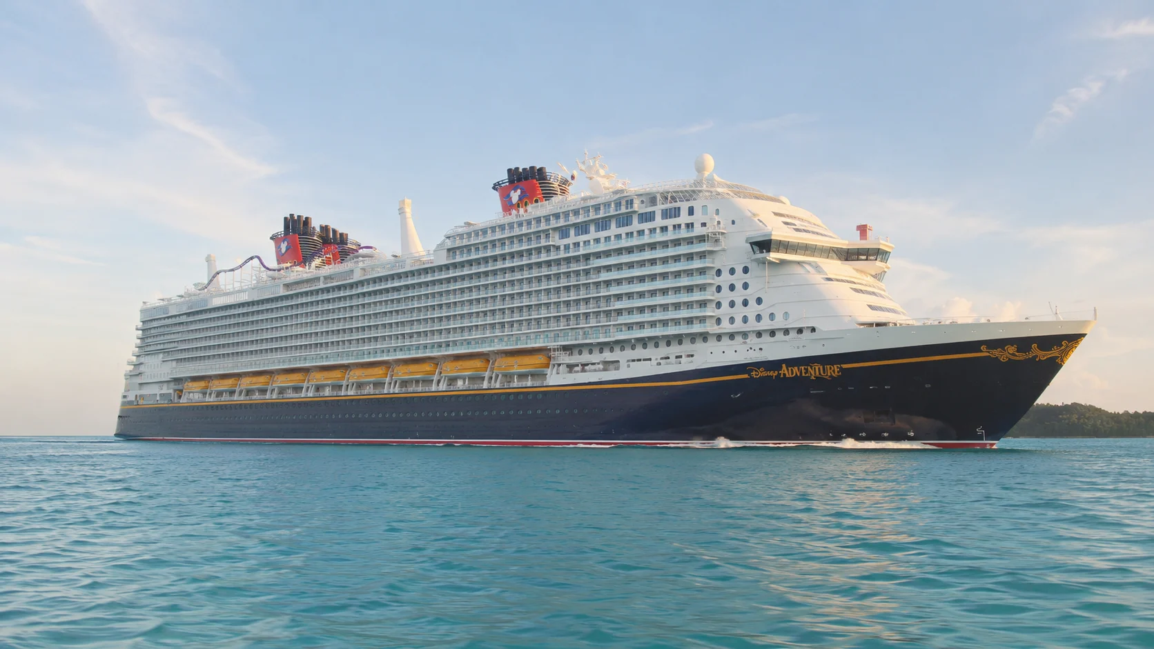 Disney cruise ship sailing across turquoise water