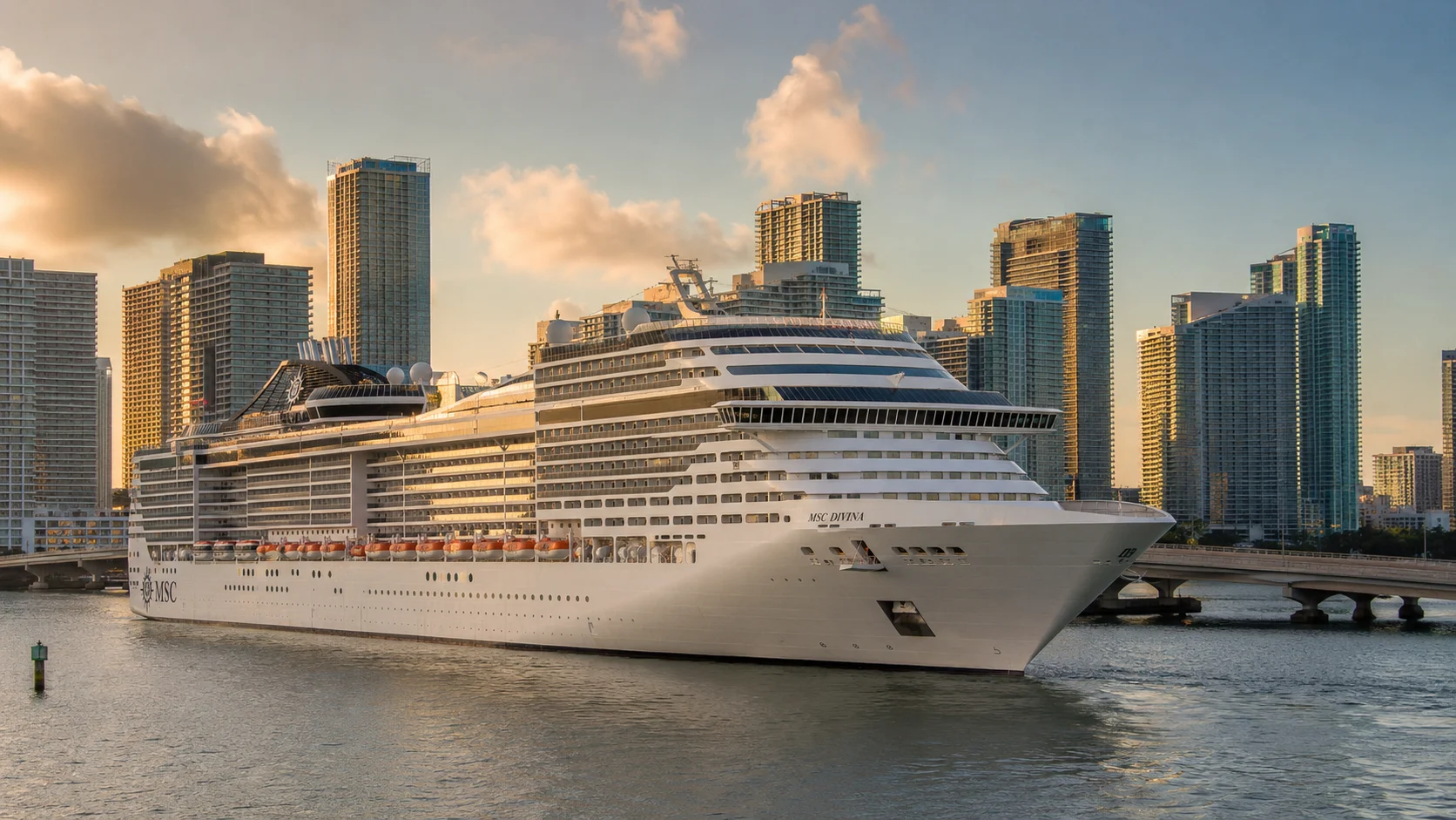 MSC Divina beside a city waterfront at sunset