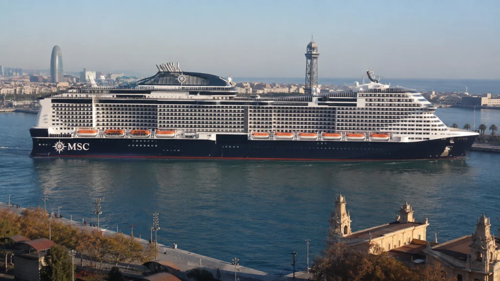 MSC cruise ship sailing beside a city waterfront