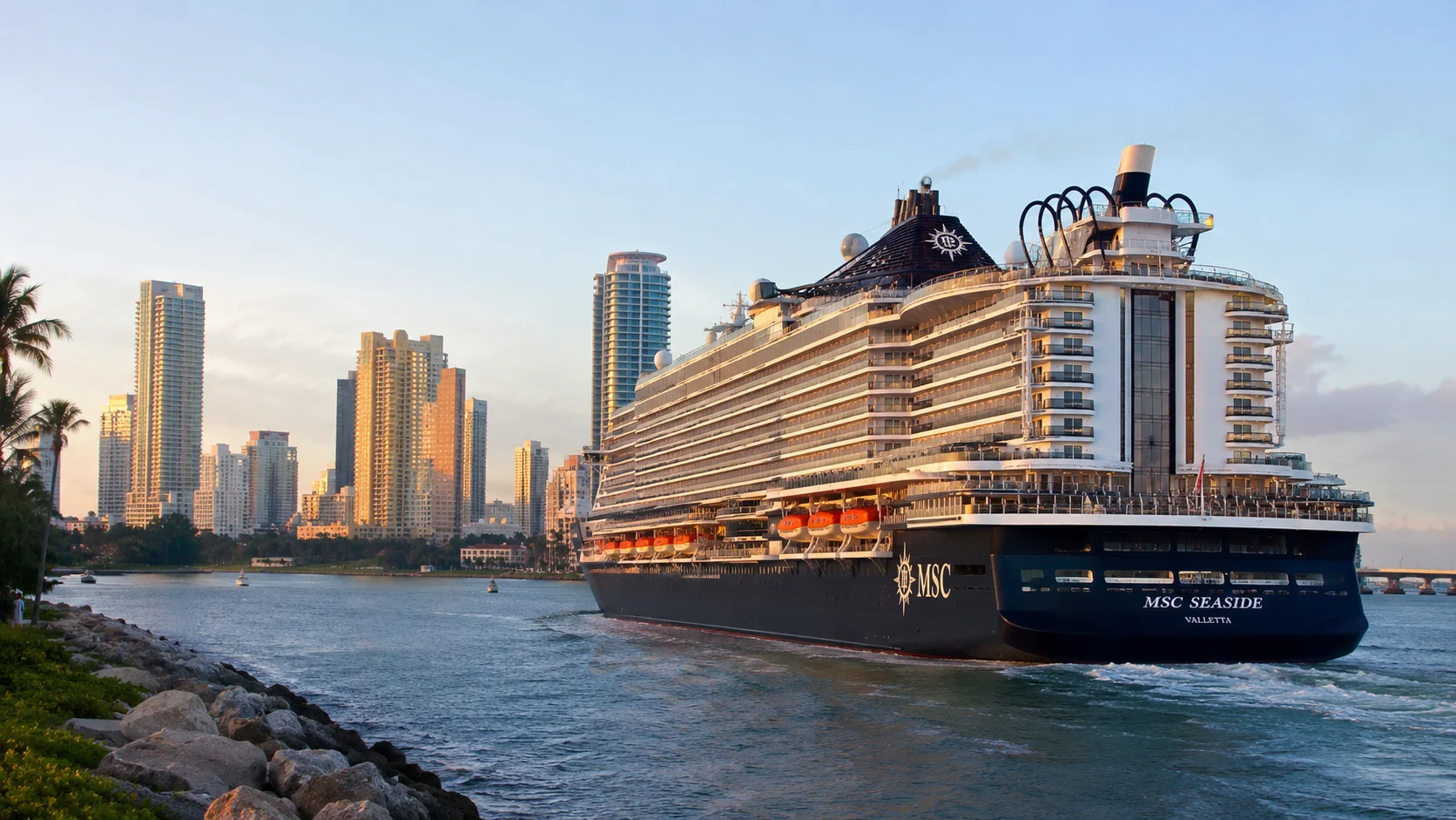 MSC Seaside sailing past a high-rise city waterfront