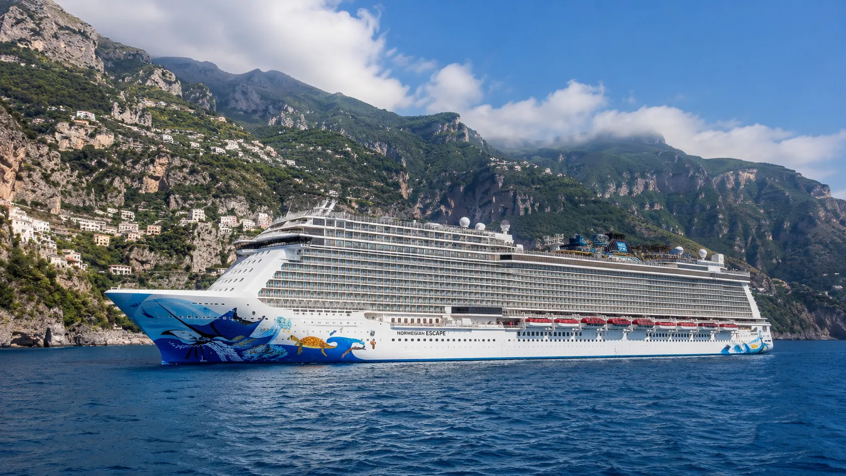 Norwegian Escape sailing beside a steep coastal town