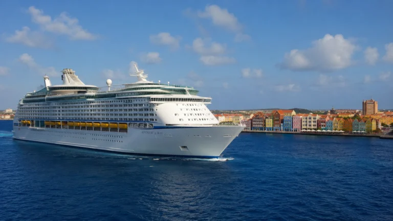 Adventure of the Seas sailing past a colorful Caribbean port