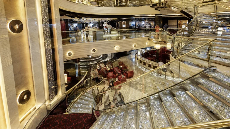 Grand cruise ship atrium with sweeping staircases and chandeliers