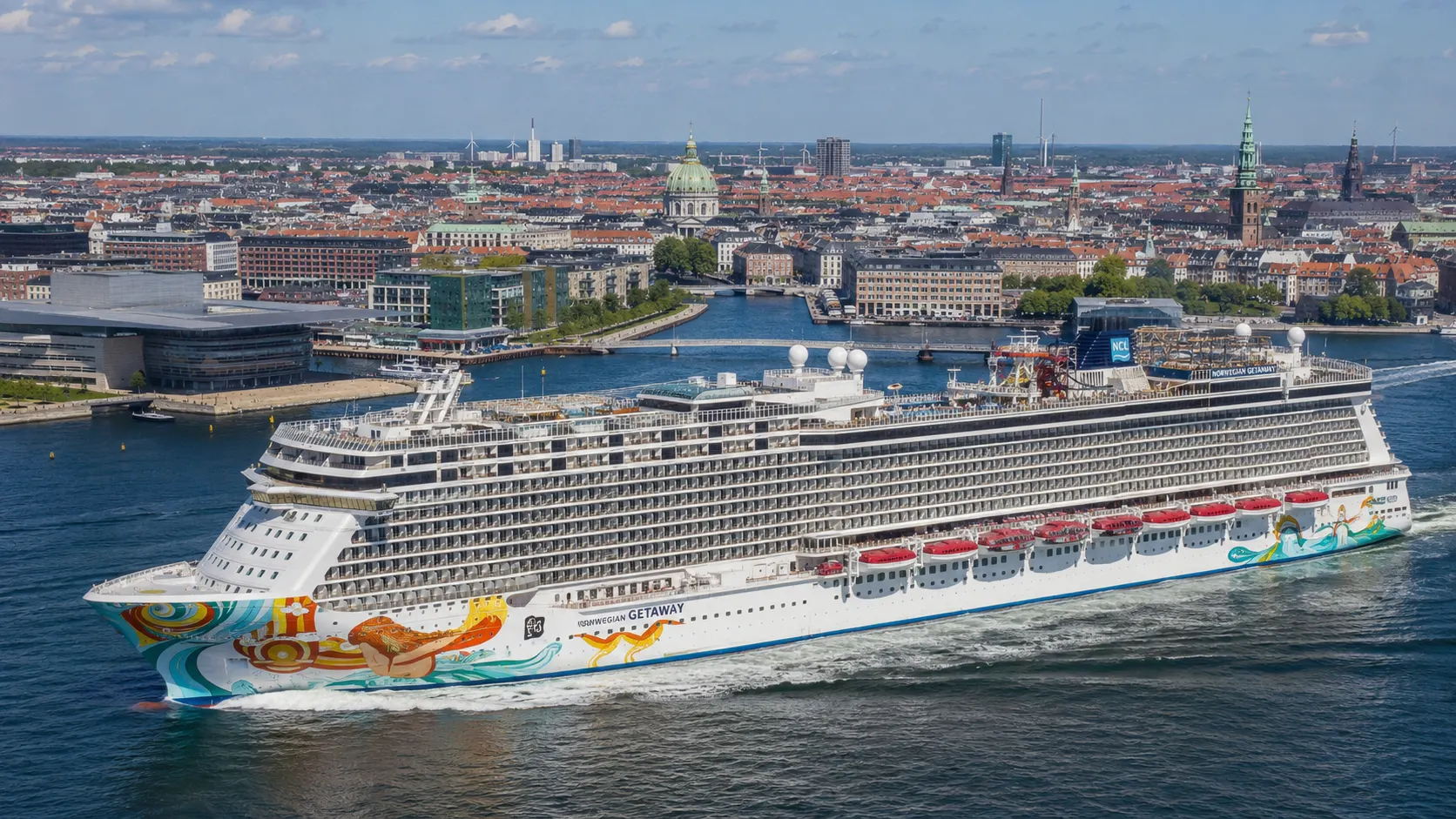 Norwegian Getaway sailing beside a city waterfront