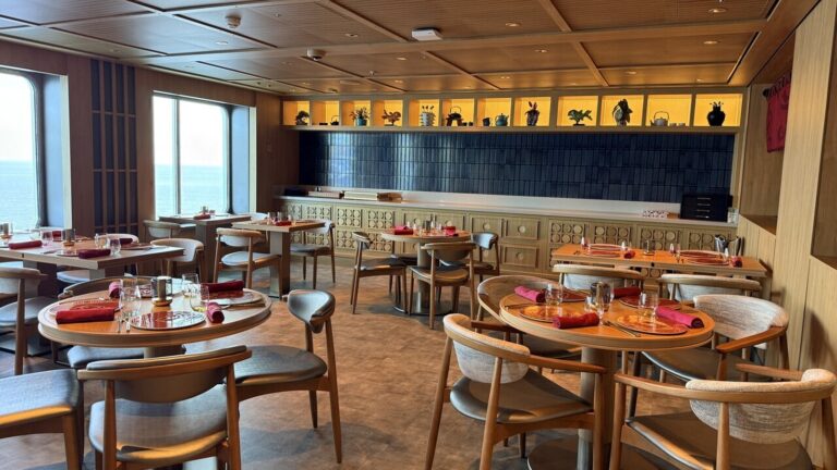 Cruise ship restaurant with wooden tables and ocean-view windows