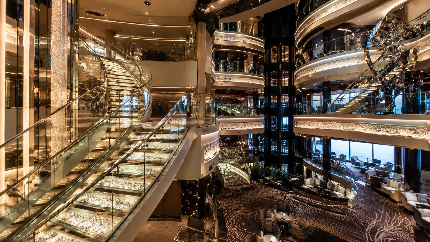 Multi-level cruise ship atrium with mirrored stairs and balconies