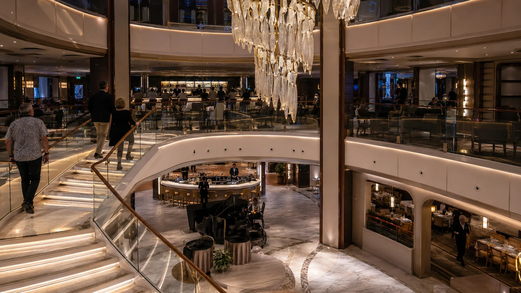 Multi-level cruise ship atrium with curved stairs and chandeliers