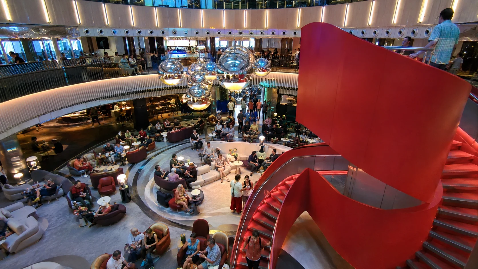 Red spiral staircase in the Roundabout atrium aboard Valiant Lady