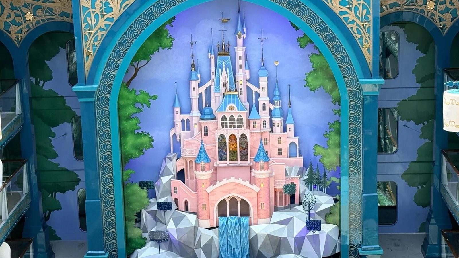 Pink fairytale castle display framed by ornate blue arches