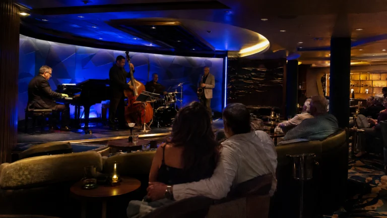 Jazz trio performing in a dim blue-lit cruise ship lounge