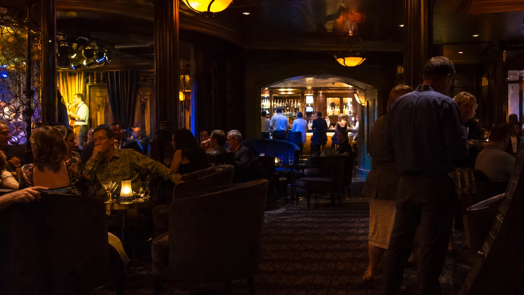 Guests relaxing in a dimly lit cruise ship nightclub