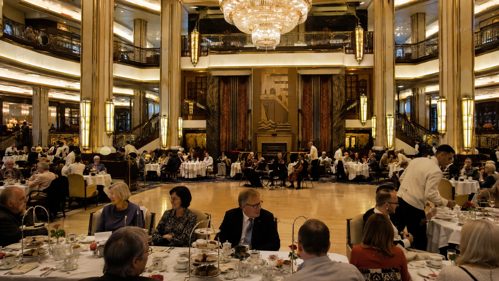 Passengers dining in an elegant two-level ballroom