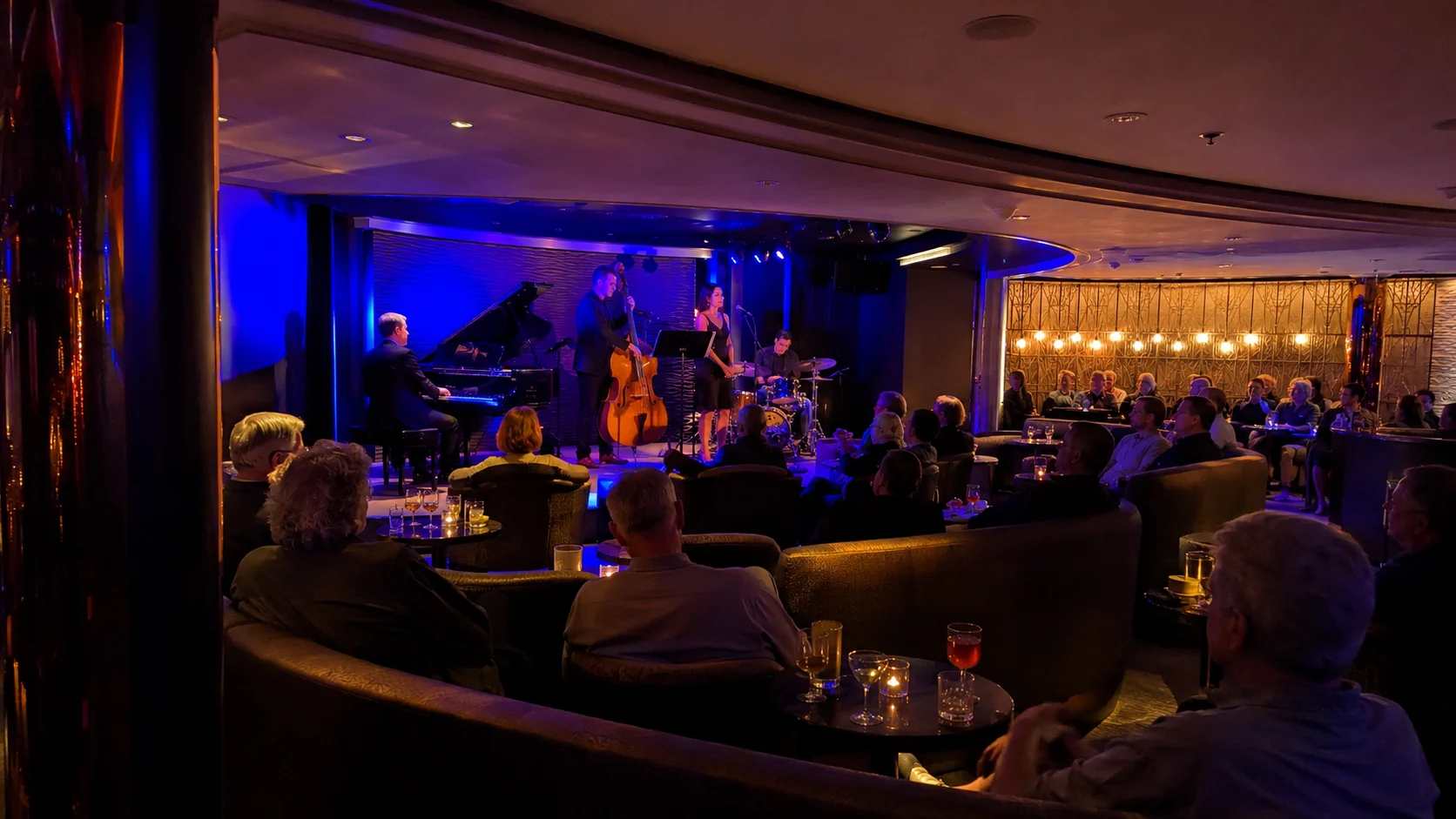 Live band performing in a blue-lit cruise ship lounge