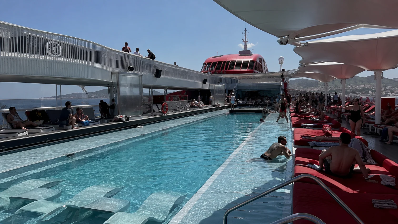 Guests relaxing around the pool aboard Resilient Lady