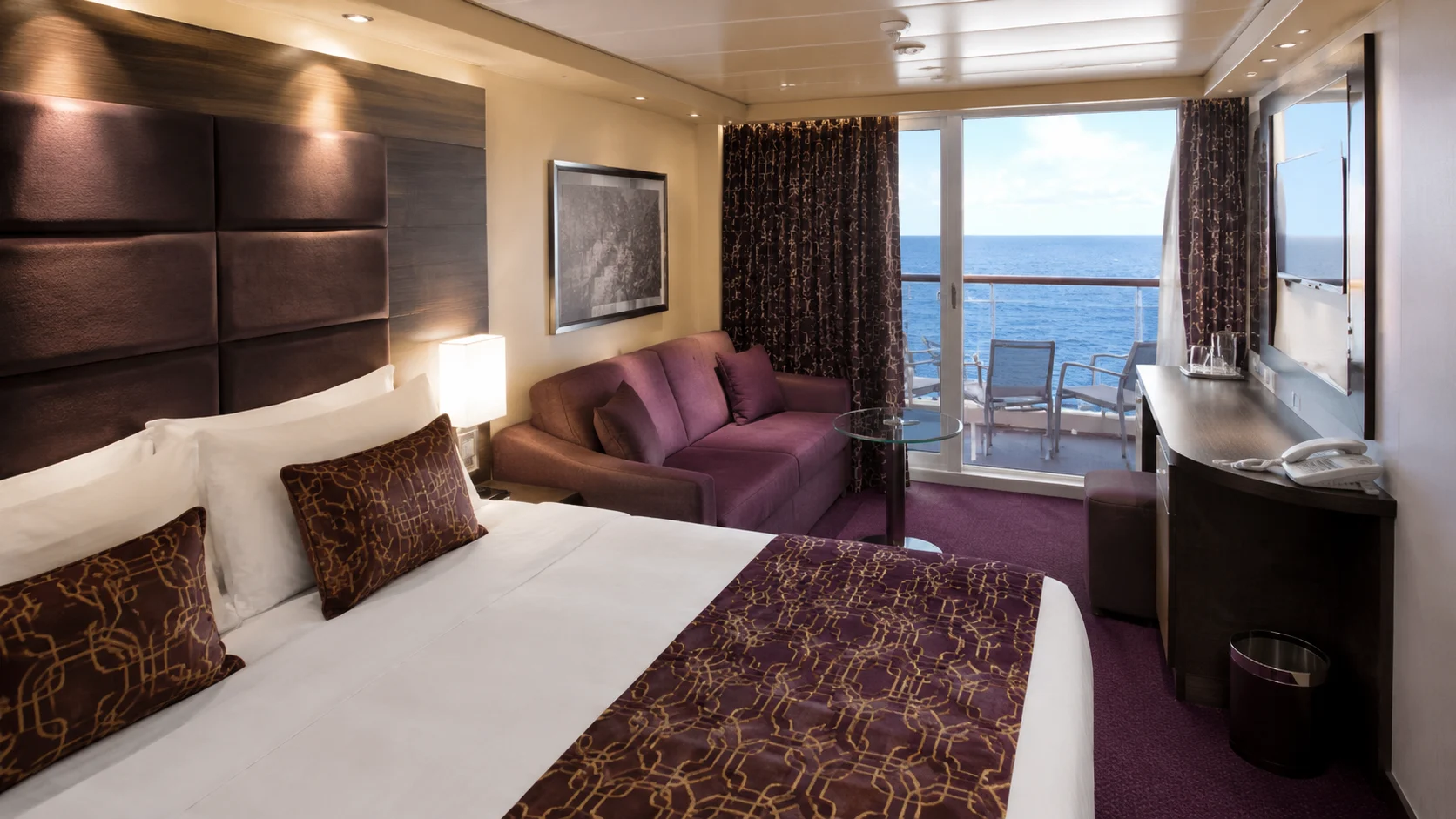 Representative MSC Divina balcony stateroom with bed, sofa and balcony doors