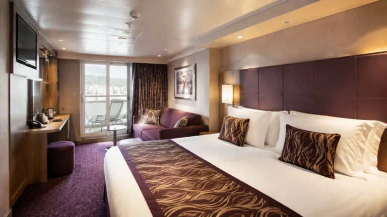 Cruise ship balcony cabin with a double bed and sofa