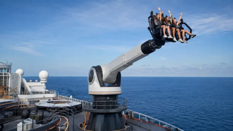 Passengers riding a mechanical arm high above a cruise ship deck