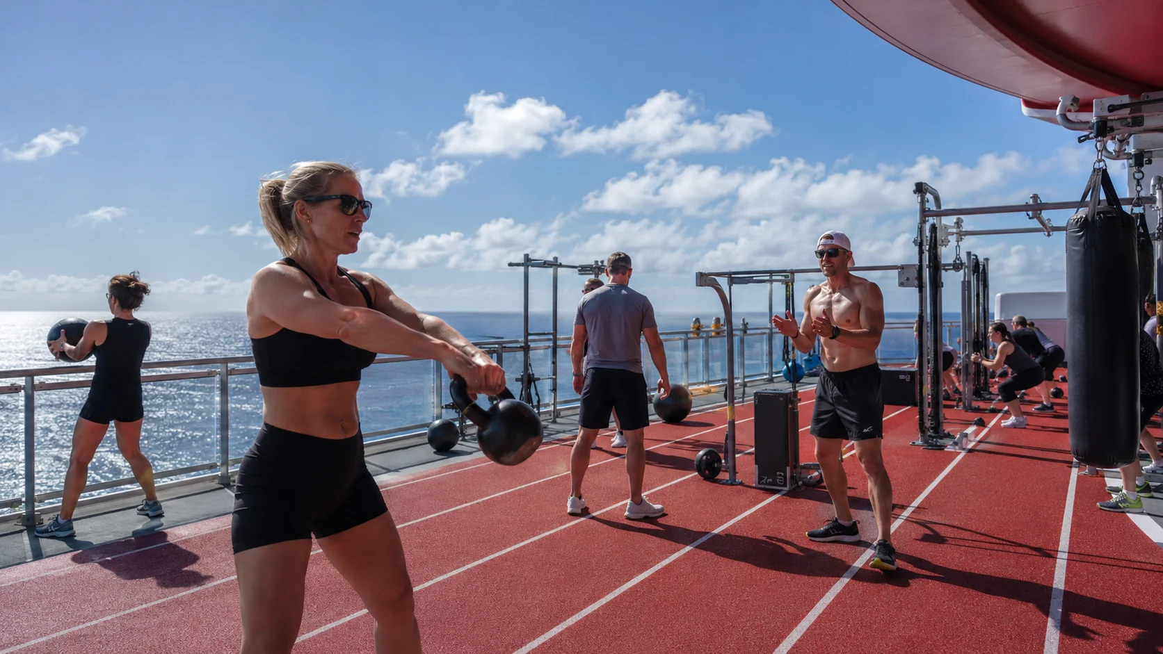 Guests exercising on the outdoor Athletic Club deck aboard Valiant Lady