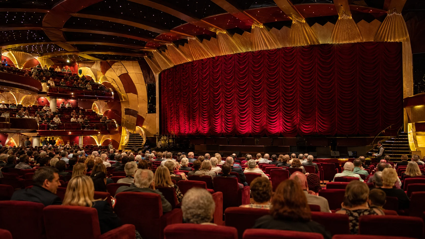 Pantheon Theater audience facing a red stage curtain on MSC Divina