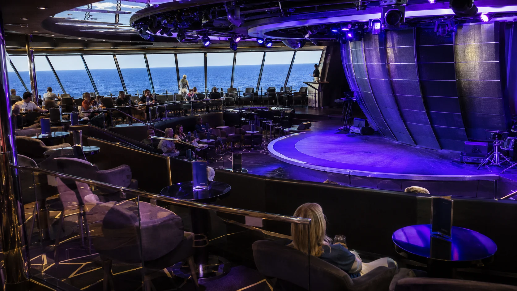 Purple-lit stage in a panoramic cruise ship lounge