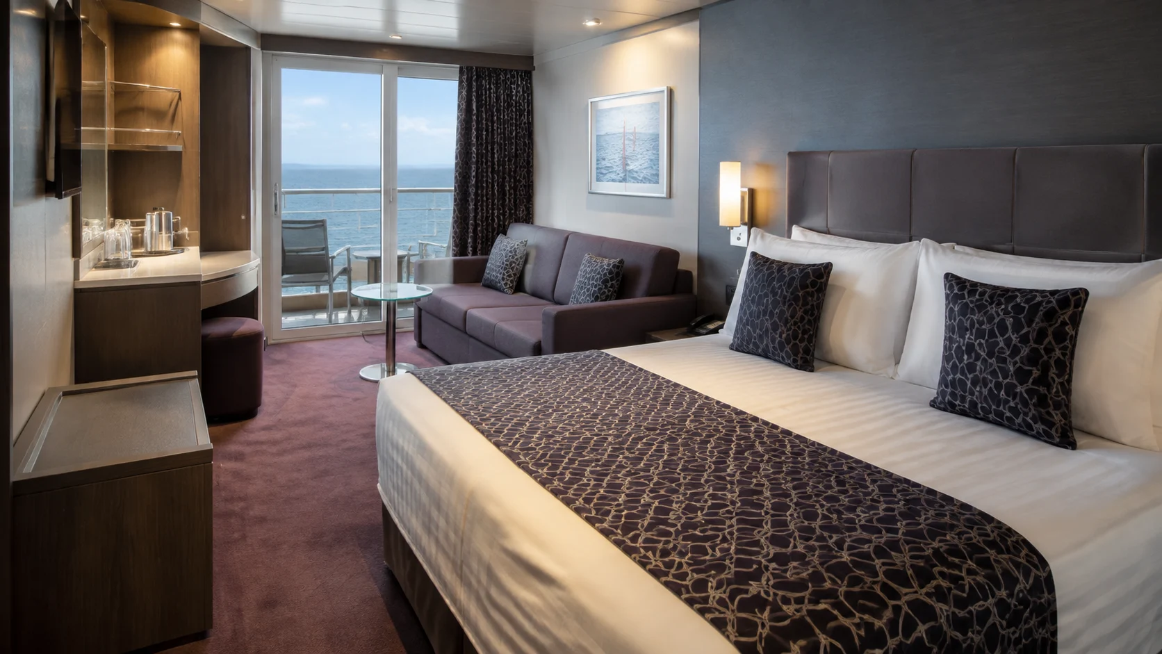 Narrow balcony cabin with a patterned bed runner and compact sofa