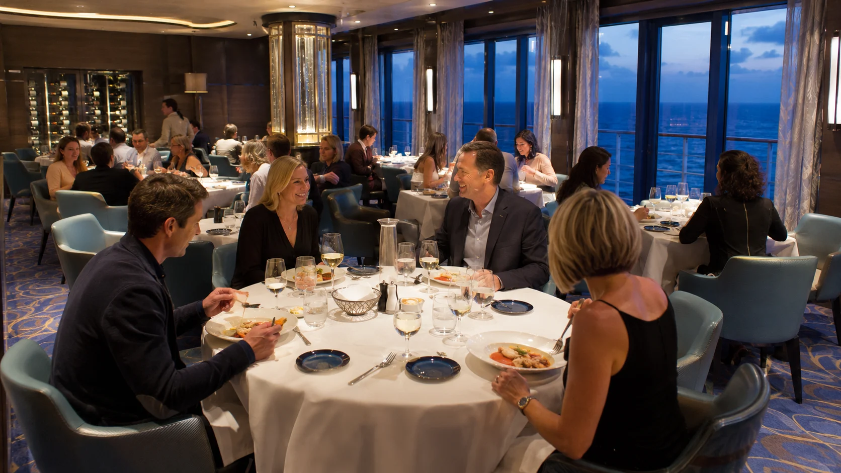 Guests dining in a formal ocean-view cruise ship restaurant