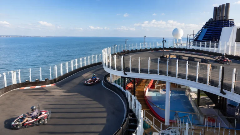 Two go-karts racing around a curved track high above the ocean