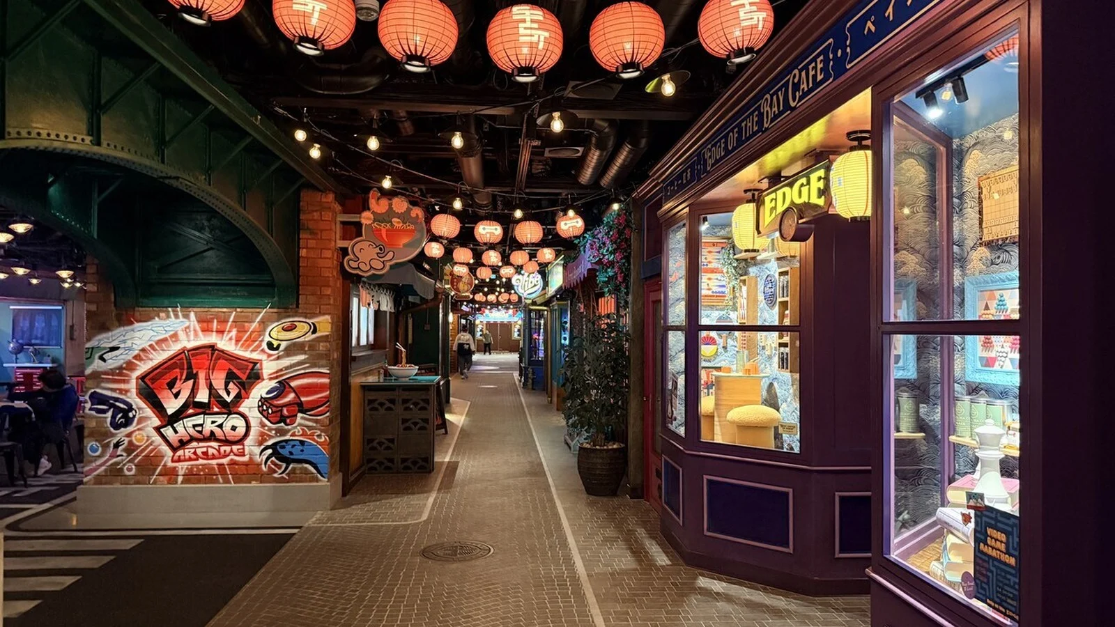 Lantern-lit passage with Big Hero 6 artwork and storefronts