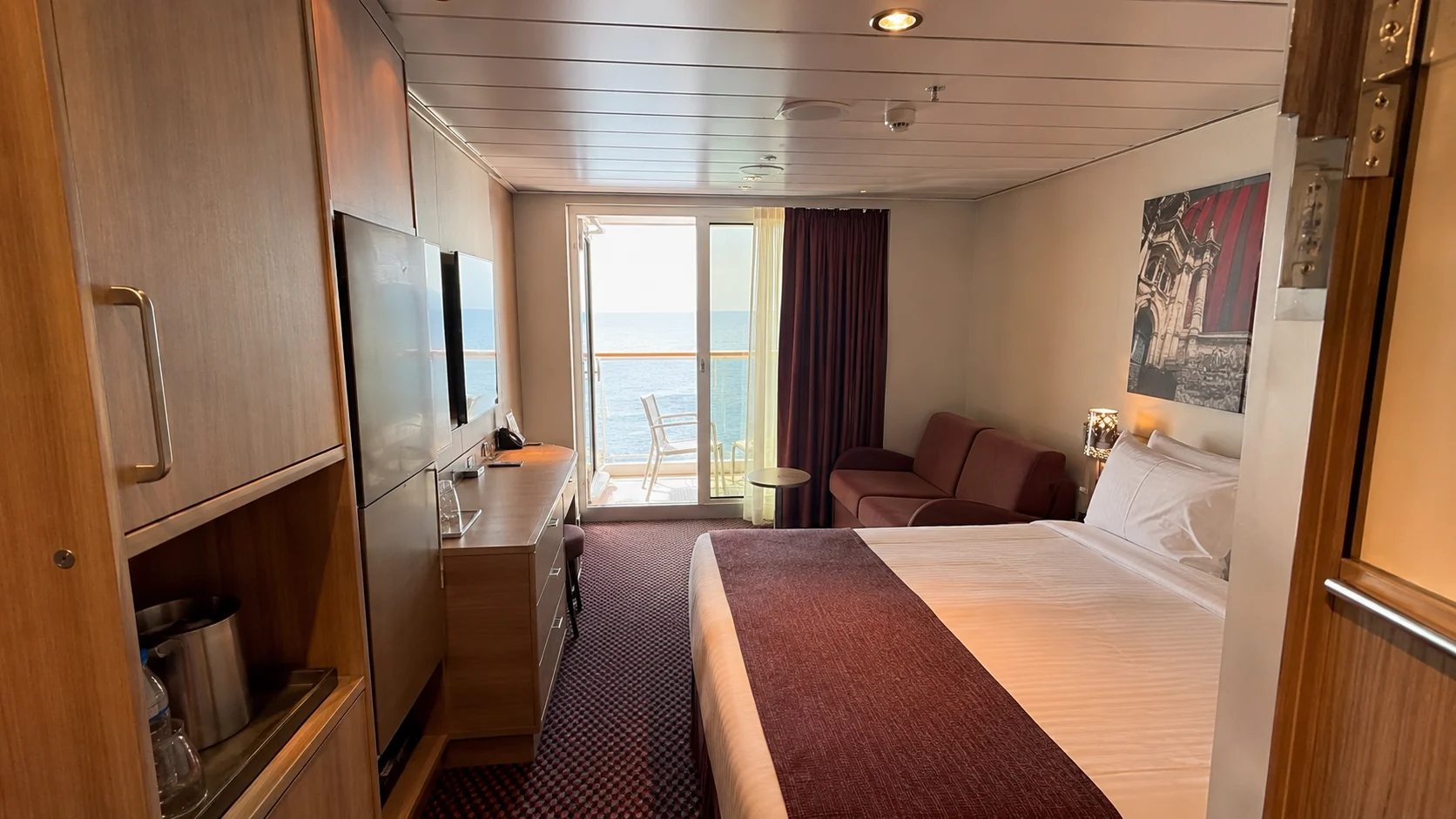 Carnival Firenze balcony cabin with a sofa and ocean view