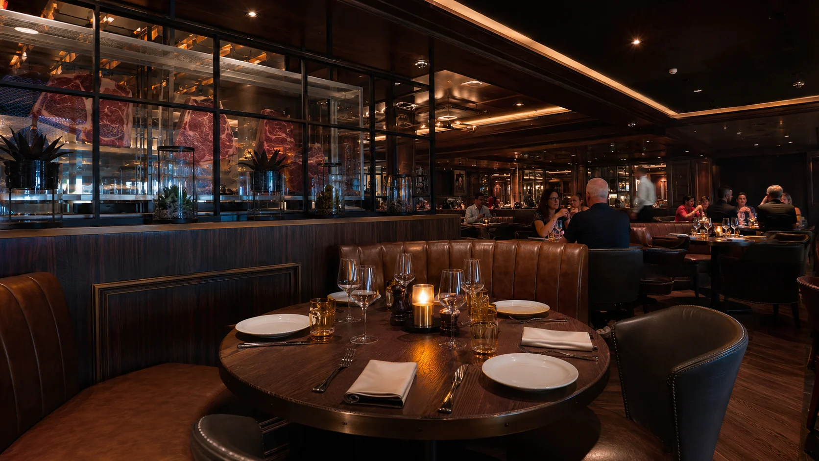 Intimate dark-wood restaurant with curved booths and set tables
