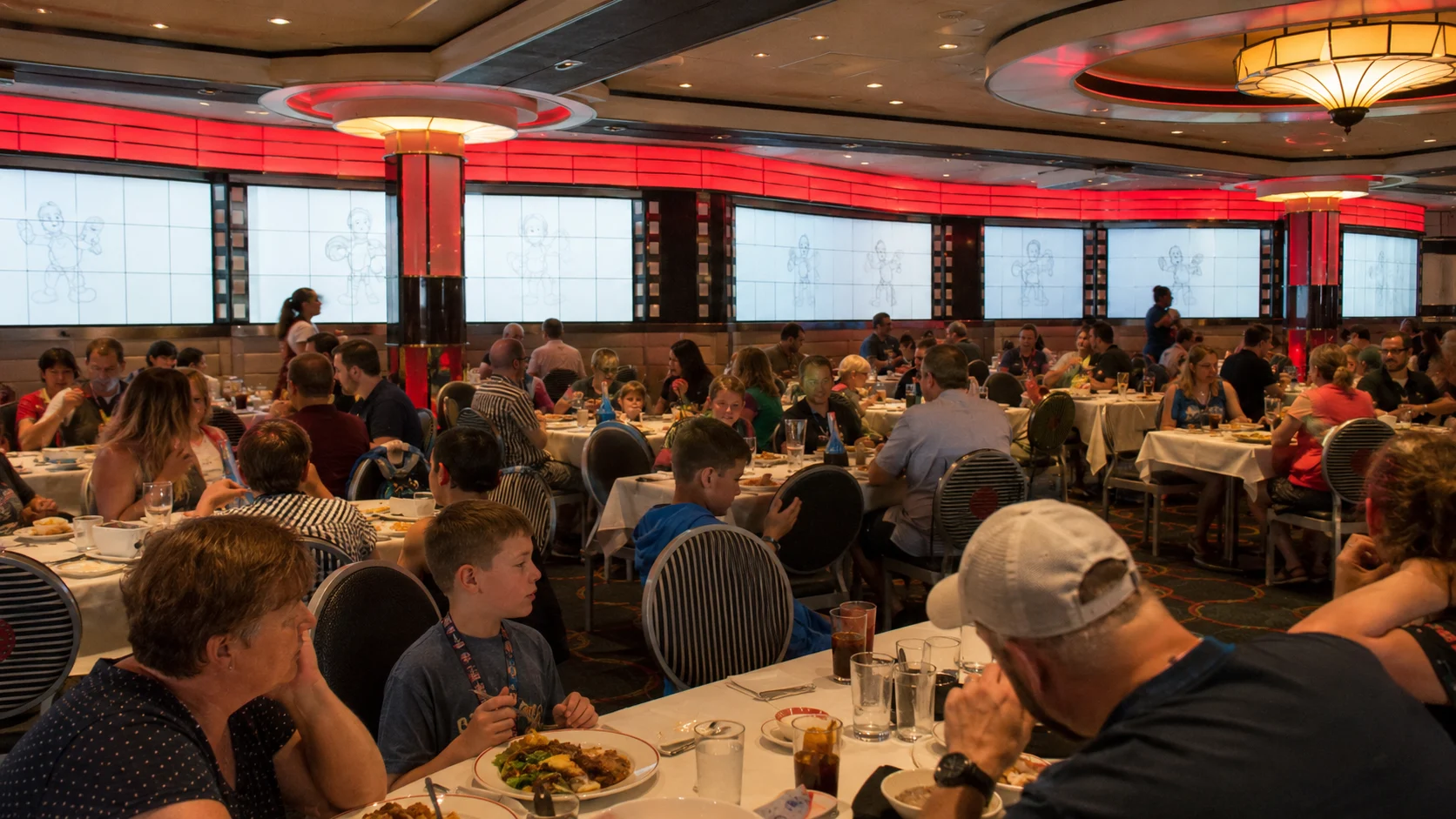 Families dining together in a colorful Disney cruise restaurant