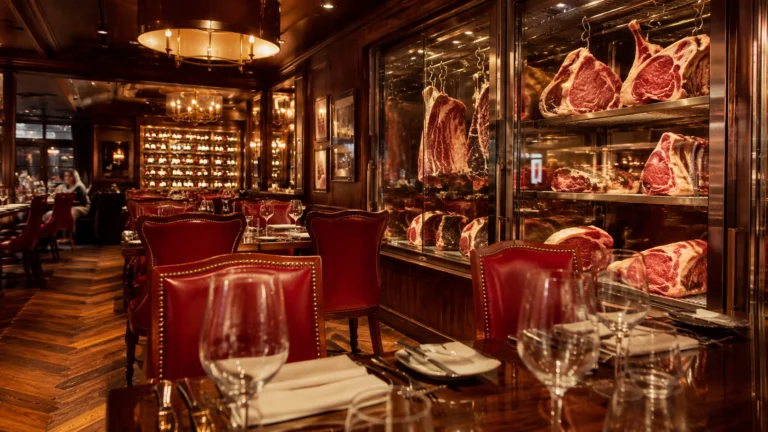 Ornate steakhouse with red leather chairs and glass meat displays