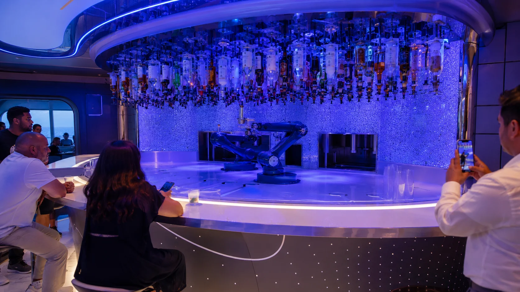 Guests seated around a futuristic blue-lit circular bar
