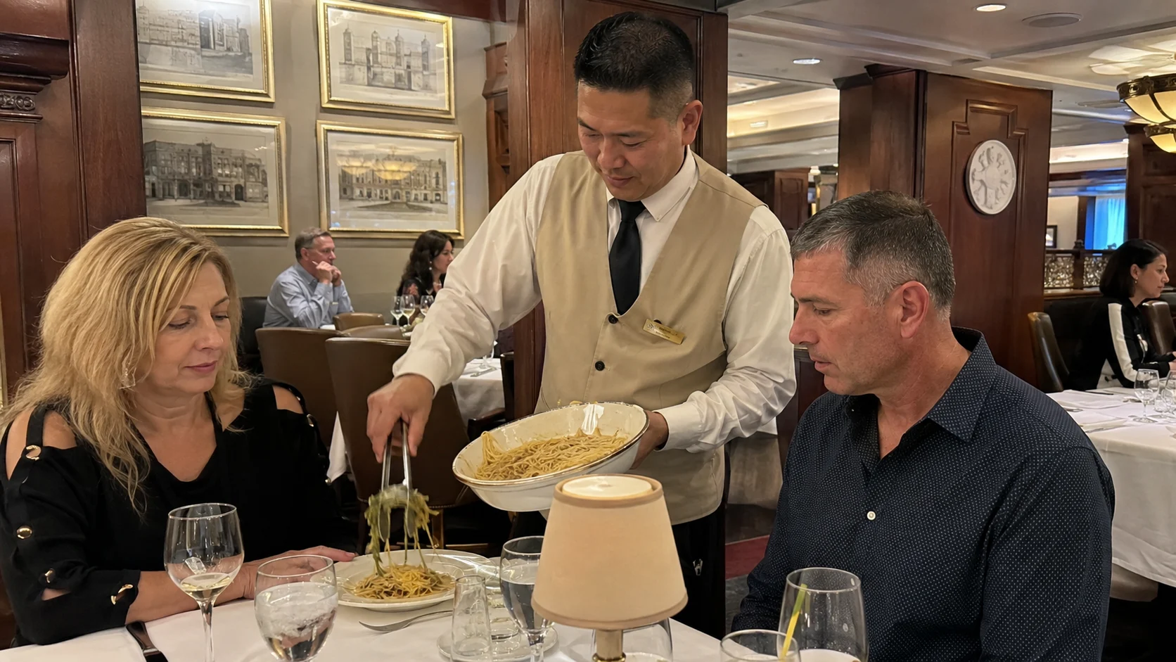 Waiter serving a couple in an intimate cruise ship restaurant