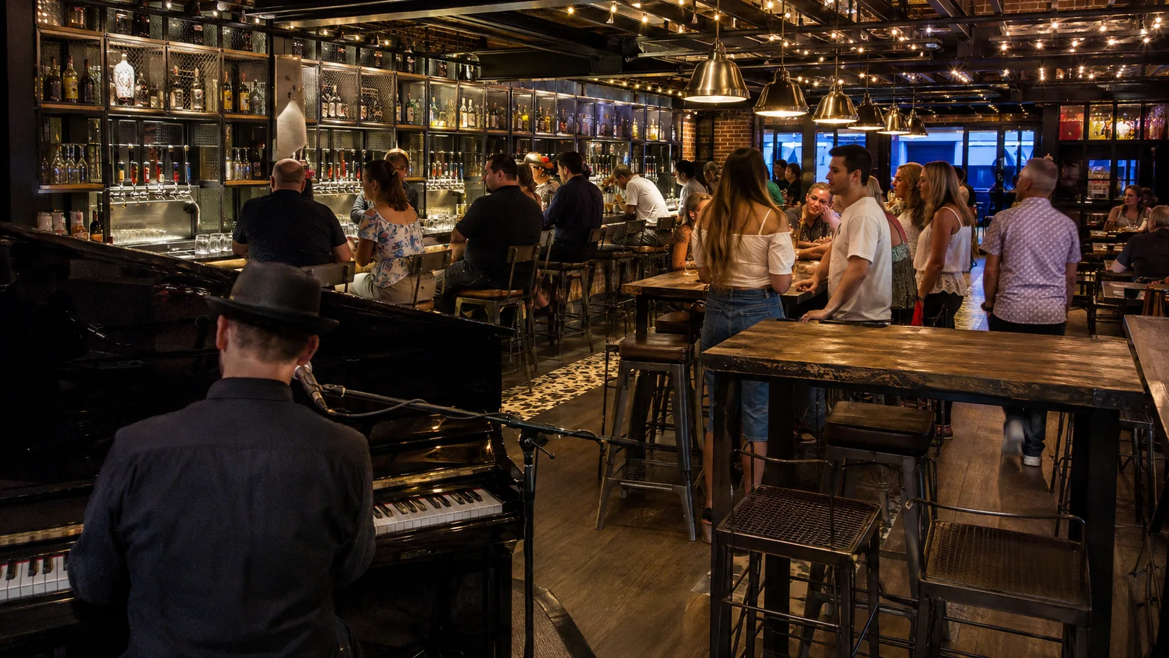 Crowded pub with a long bar and hanging glassware