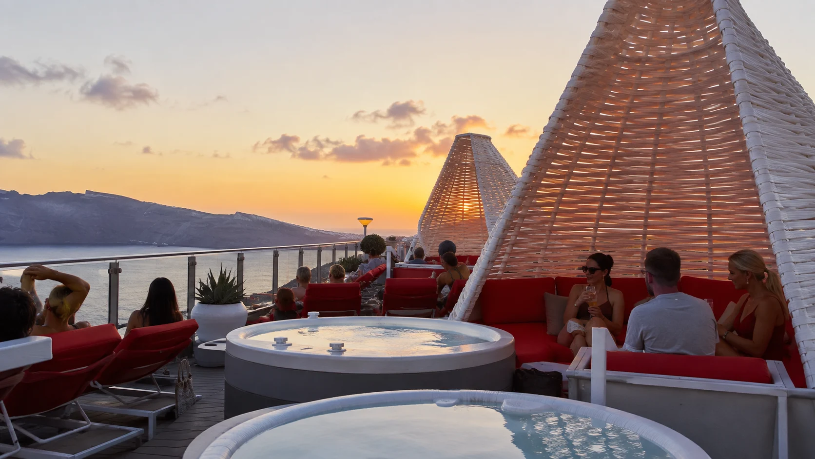 Hot tubs and red loungers at Richard's Rooftop during sunset