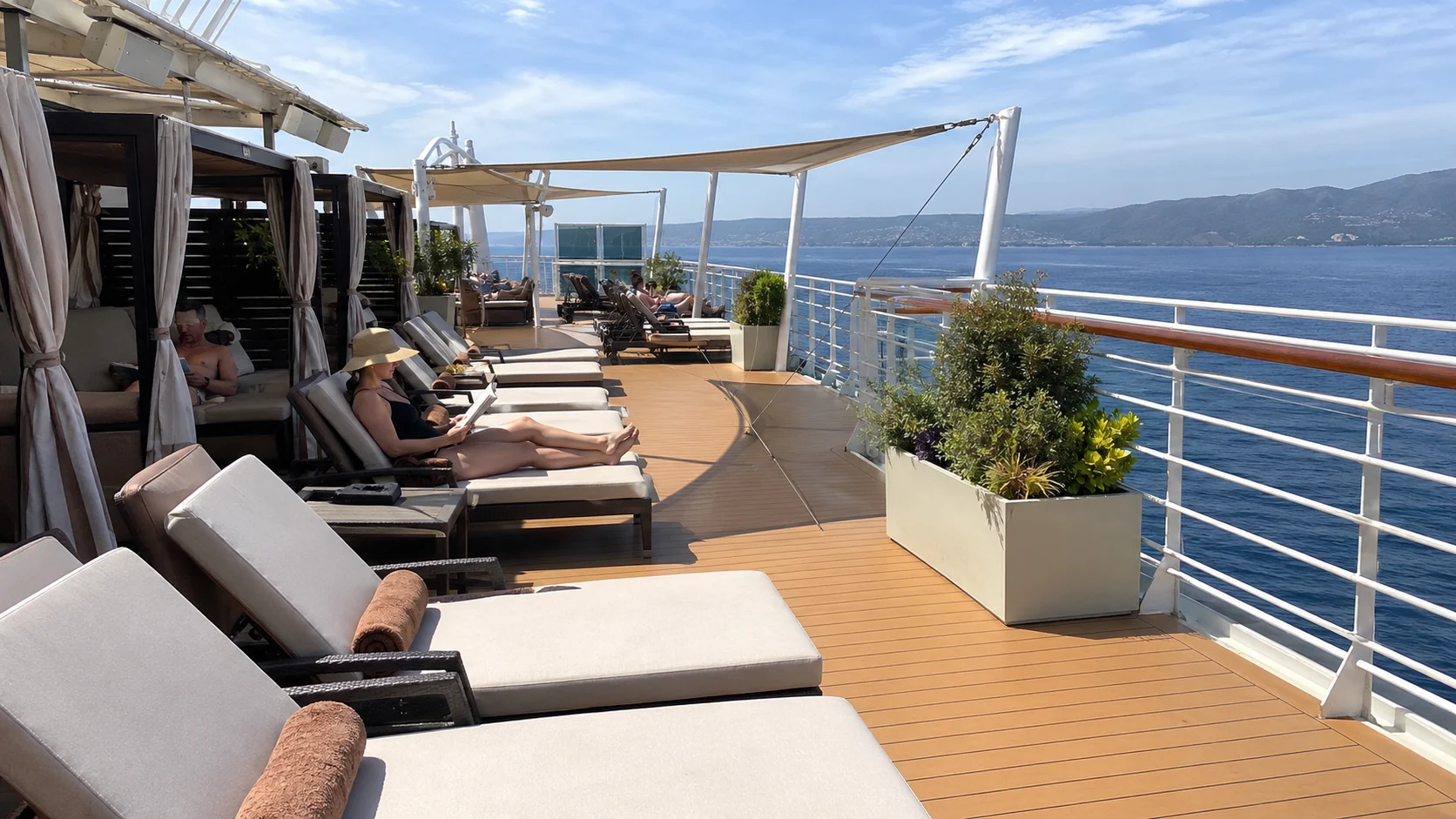 Quiet adults-only sun deck with padded loungers and ocean views
