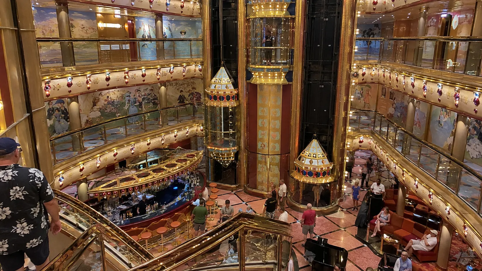 Ornate multilevel cruise ship atrium with glass elevators
