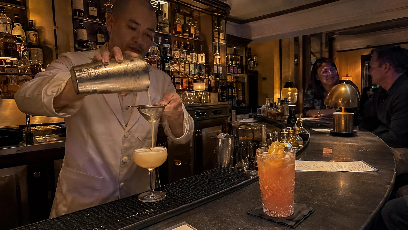 Bartender pouring a cocktail at Alchemy Bar aboard Carnival Liberty