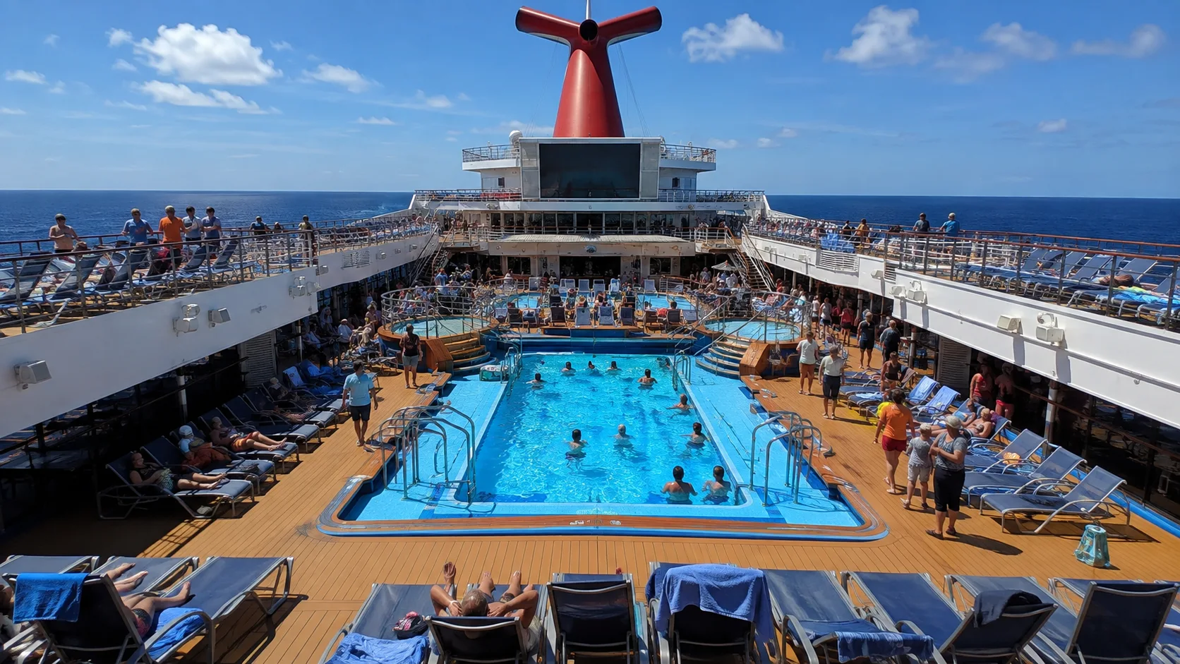 Passengers swimming and sunbathing around Carnival Liberty's Lido pool