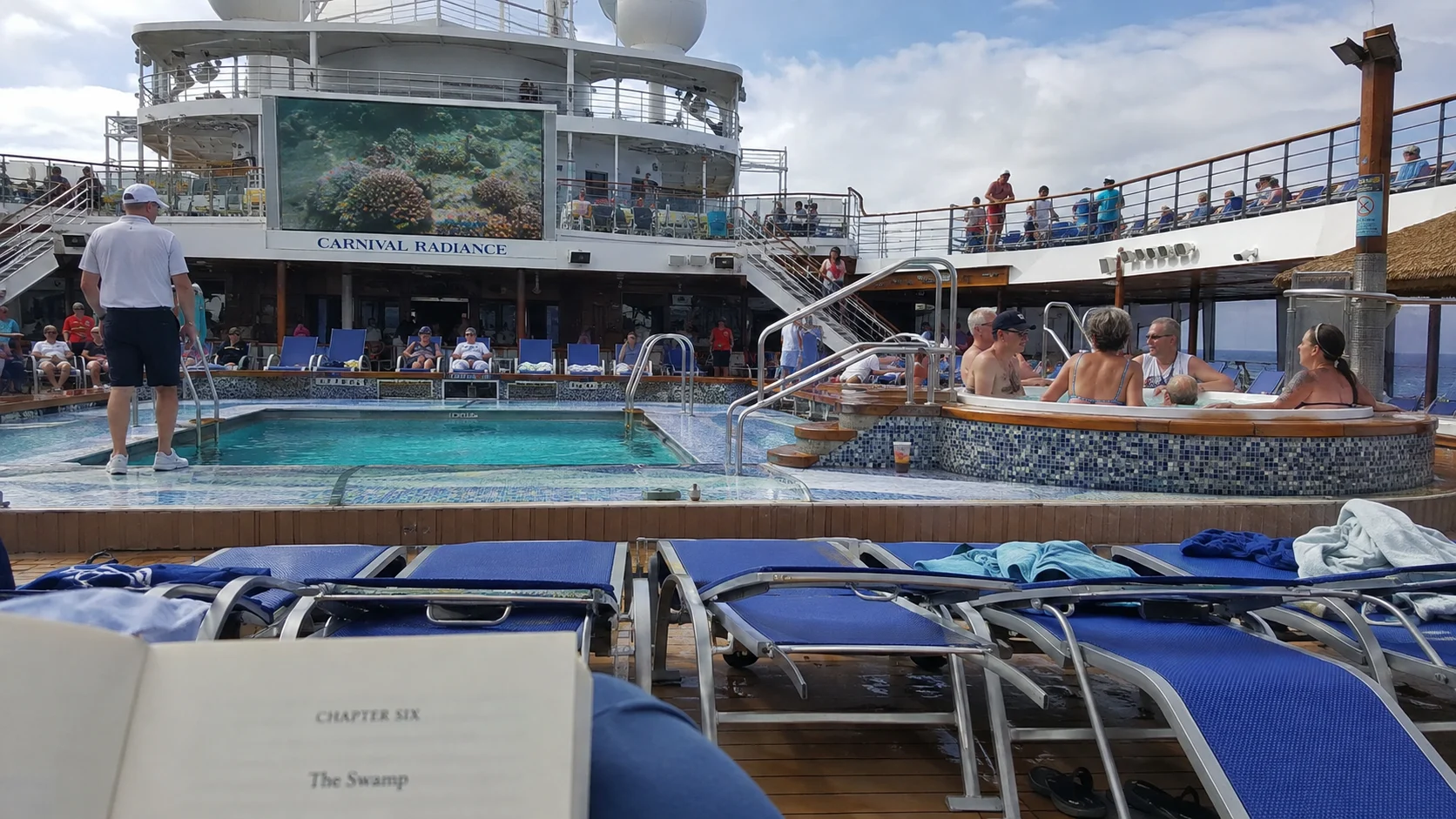 Passengers relaxing in a hot tub beside a cruise ship pool