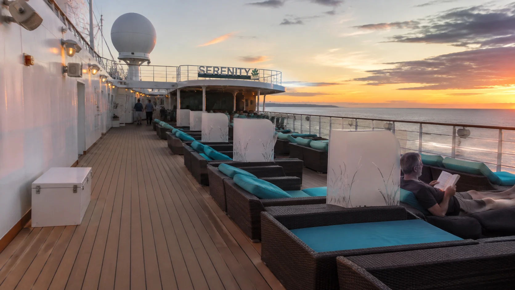 Lounge chairs on a Serenity cruise ship deck at sunset