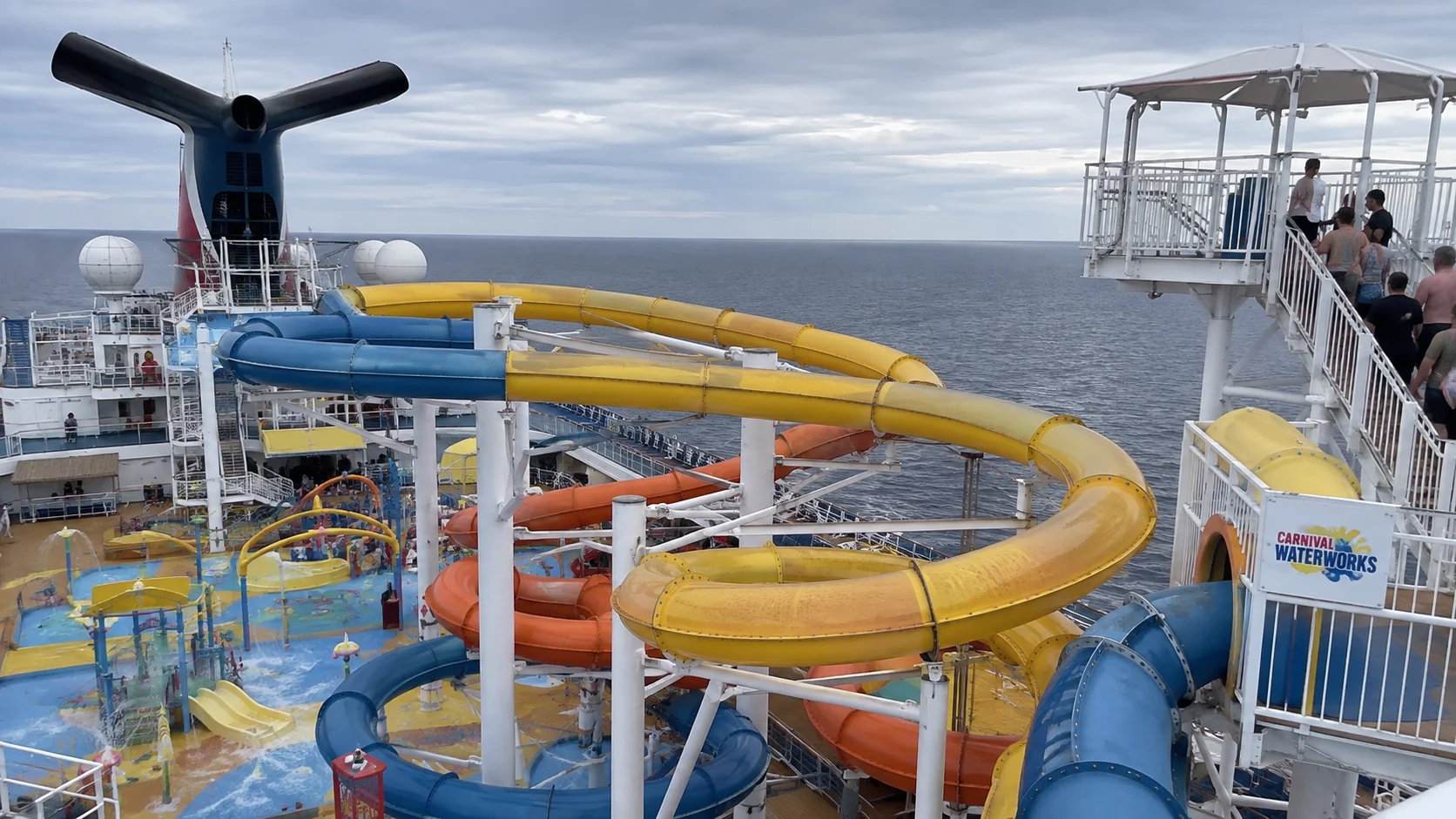 Twisting yellow, blue, and orange waterslides on a cruise ship