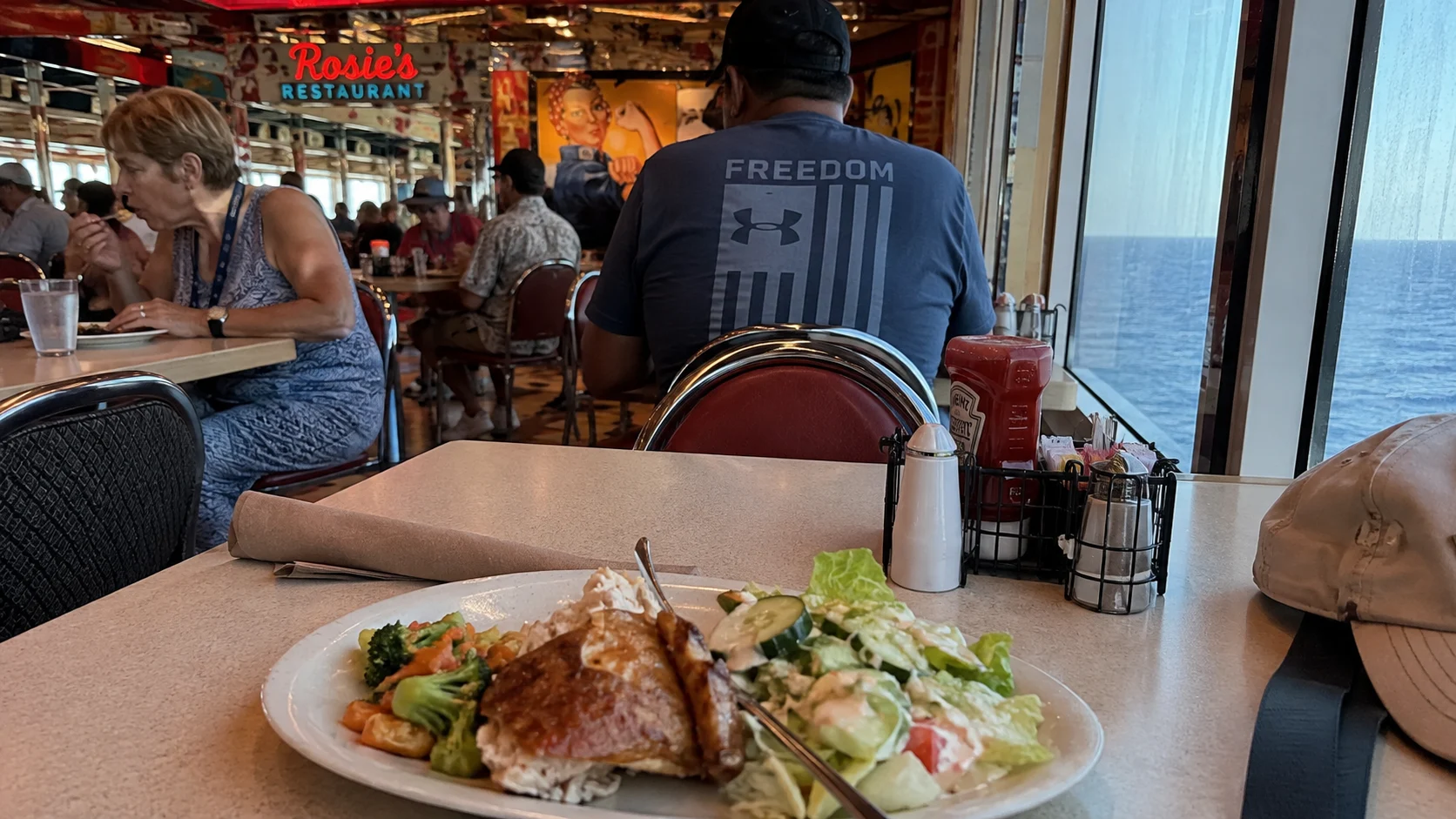 Plate of food on a window-side table in Carnival Valor's buffet