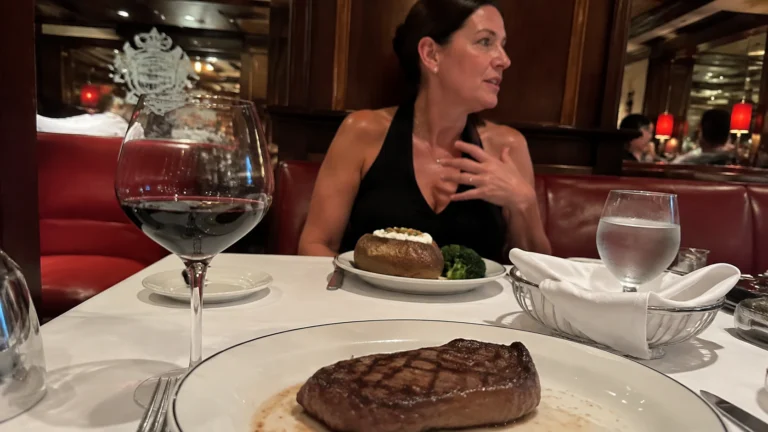 Steak and red wine at a cruise ship restaurant table with a dining companion