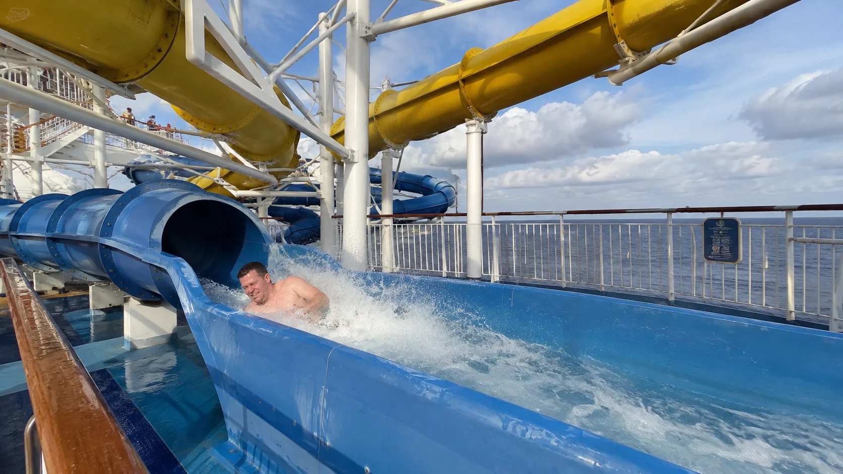 Passenger splashing out of Carnival Valor's blue waterslide