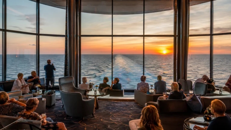 Two70 lounge overlooking the ocean at sunset aboard Ovation of the Seas