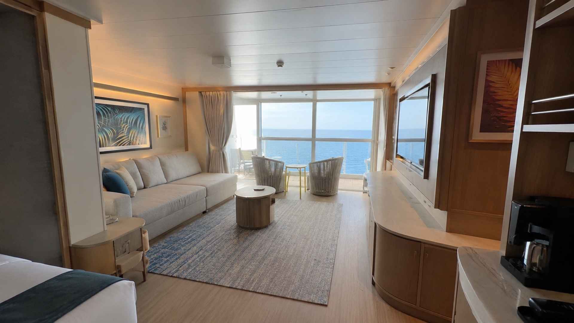 Suite living area with a sofa, coffee table and a large ocean-facing window