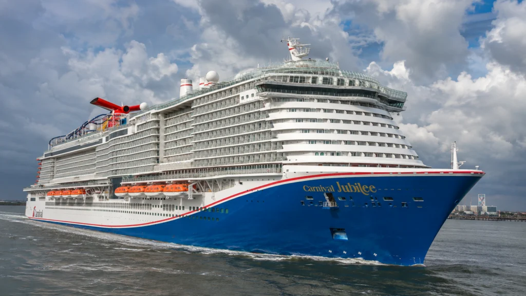 Close bow view of Carnival Jubilee beneath dramatic clouds