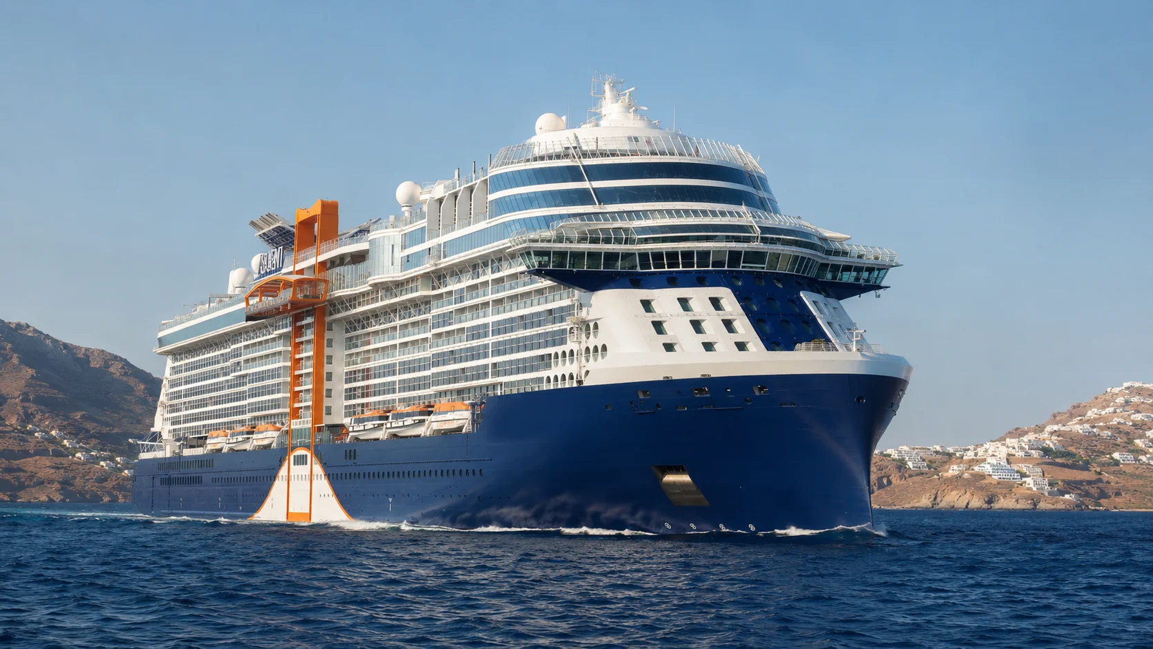 Celebrity Ascent sailing past a coastal town